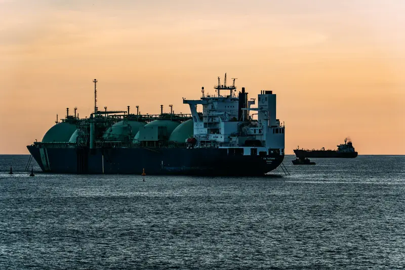 An LNG carrier with spherical cargo tanks at sea at sunset