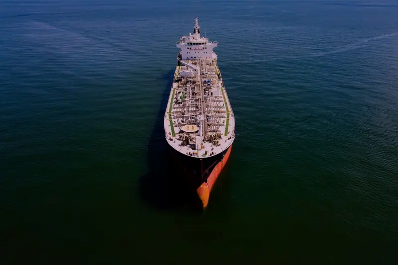 A loaded crude oil tanker at sea at sunset